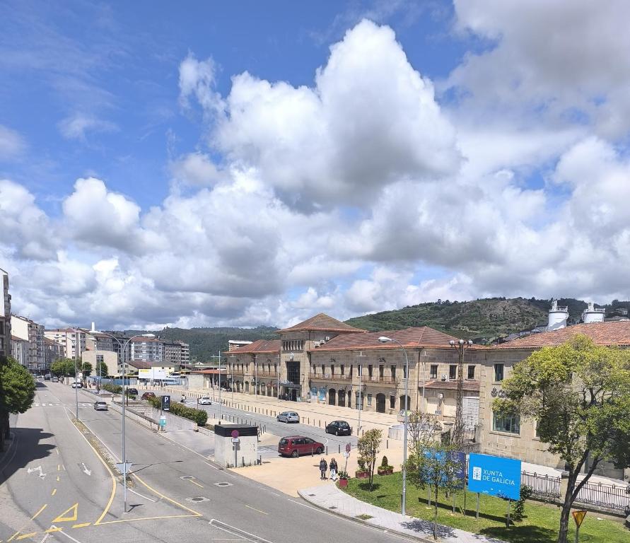 a city street with buildings and cars on the road at Hostal Cafetería La Rotonda in Ourense