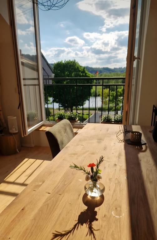 a wooden table with a vase with a flower on it at moselquartier terlinden- Loft in Perl