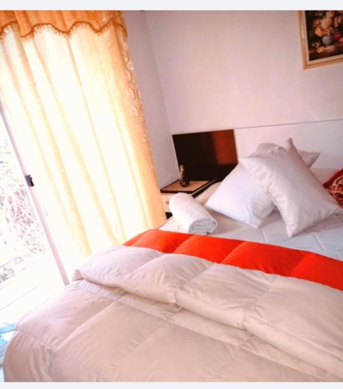 a bedroom with a bed with a red and white blanket at El secreto in Ciudad de la Costa