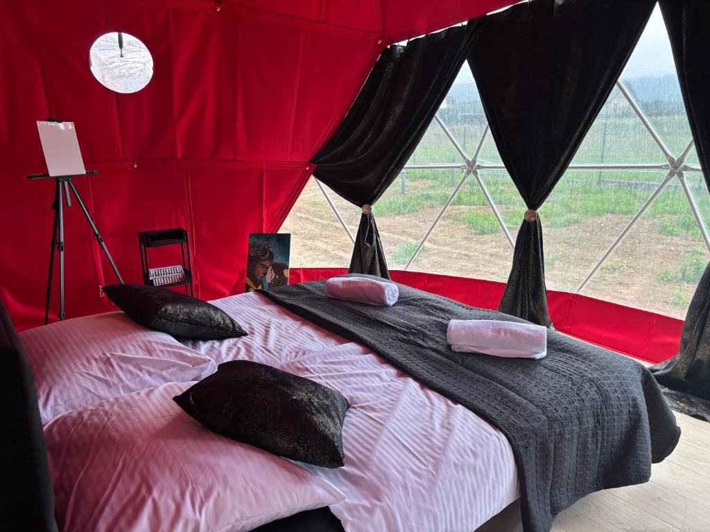a bed in a red tent with a window at Glamping Izerska Bajka in Mirsk