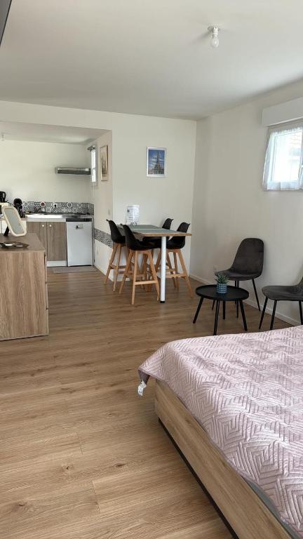 a room with a bed and a table and chairs at Studio 1 avec extérieur in Saran