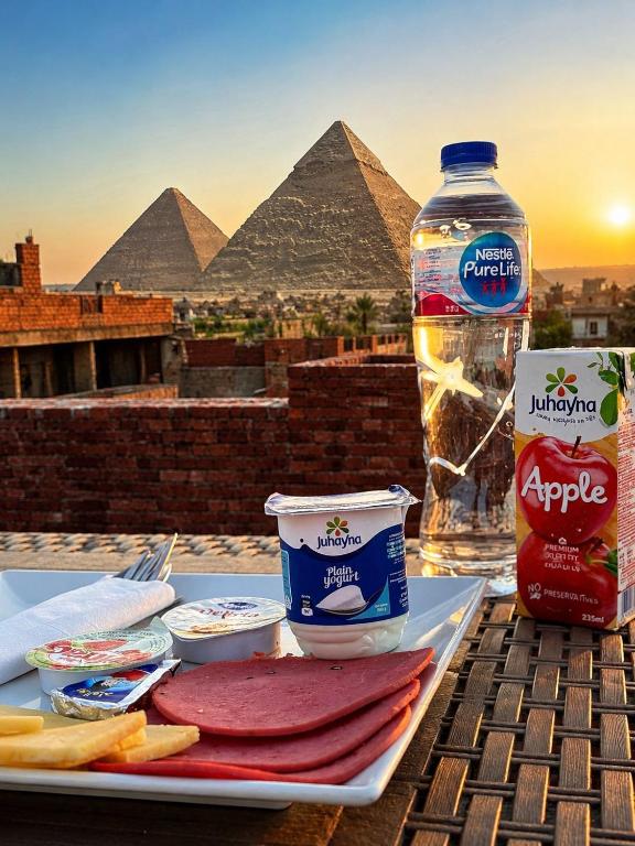a table with a plate of food and a bottle of water at Casa Latina pyramids view in Cairo