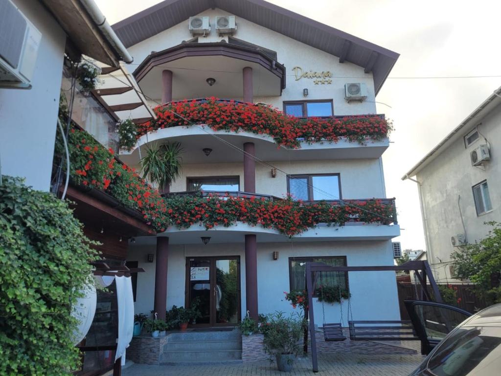 a building with flowers on the side of it at Pensiunea Daiana in Mamaia Sat/Năvodari