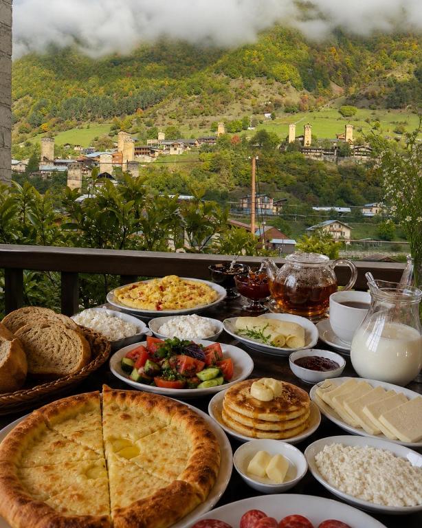 a table topped with lots of different types of food at Guest House Nikala in Mestia