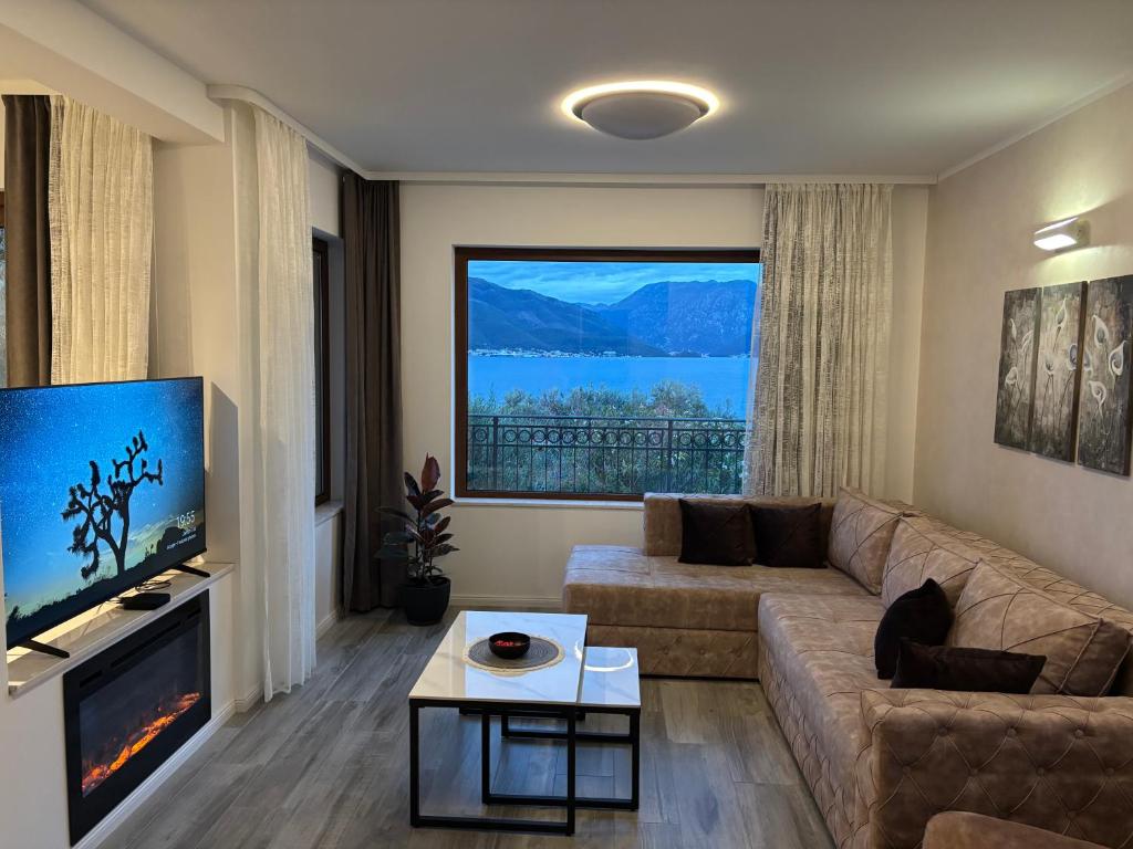 a living room with a couch and a large window at Boka Hub Apartments in Krašići