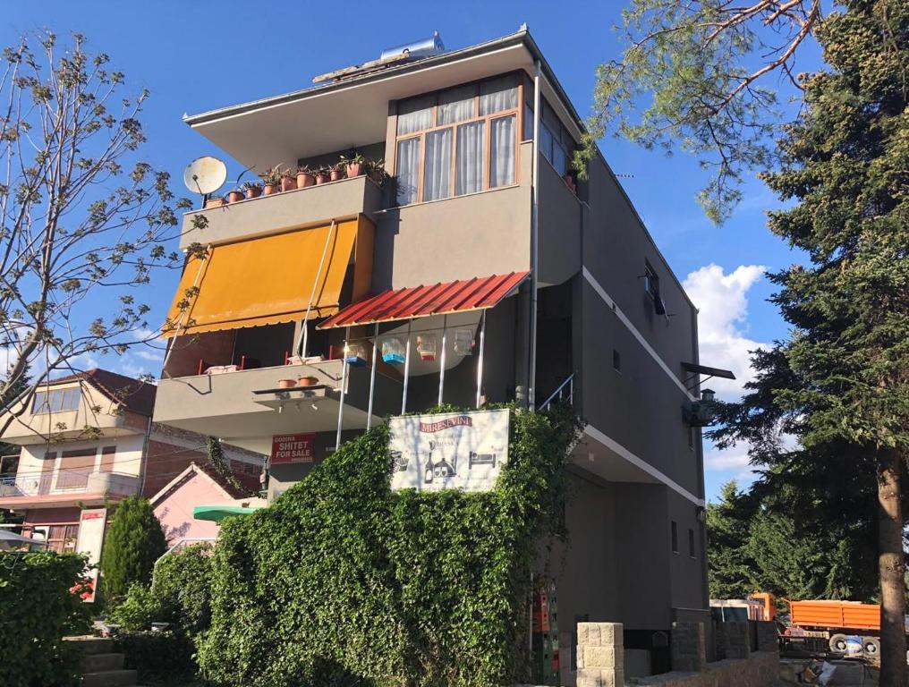 a building with people sitting on top of it at Bar Restaurant Hotel Drraska in Maliq
