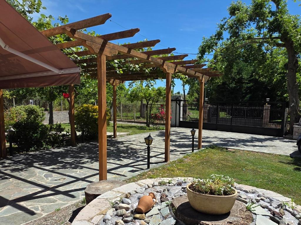 a garden with a wooden pergola and a fire pit at Coral Bungalow in Rákhai