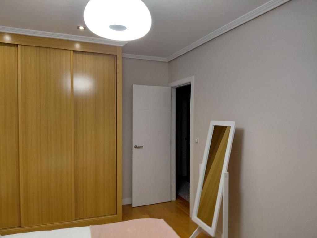 a bedroom with a wooden closet and a mirror at A casa de Aliciña in Sanxenxo