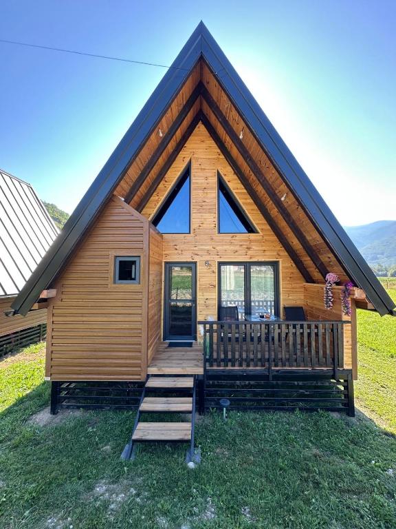 a log cabin with a large gambrel roof at Agin Konak in Gusinje