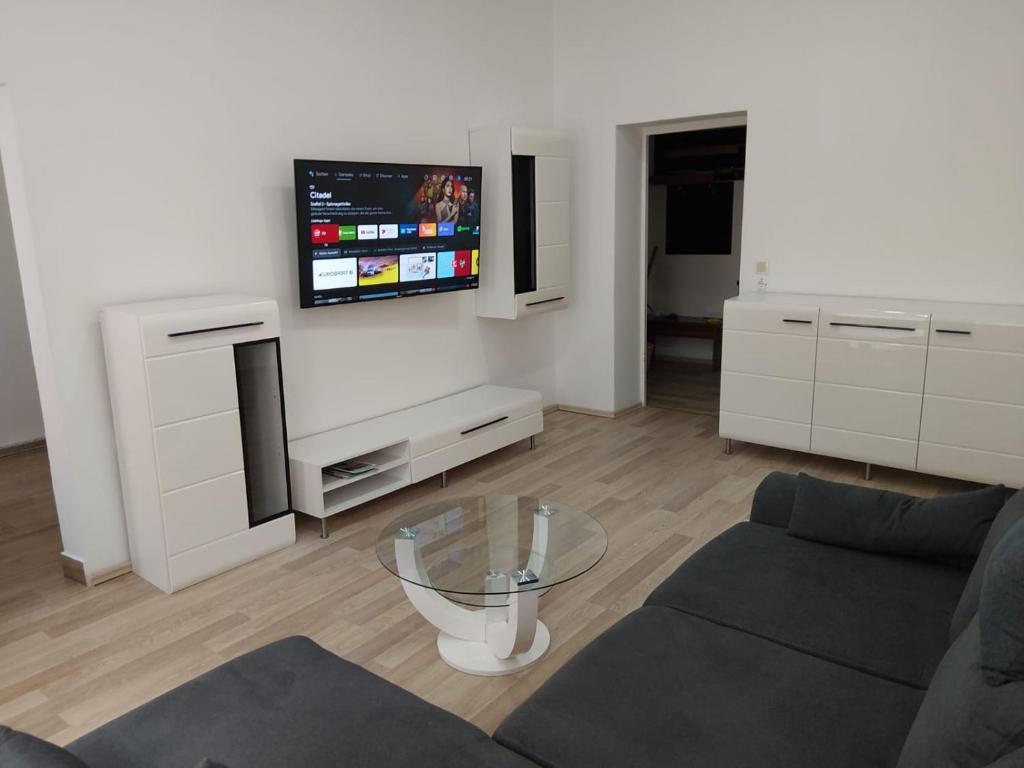 a living room with a couch and a tv on a wall at HOME Prime Stay Chemnitz in Chemnitz