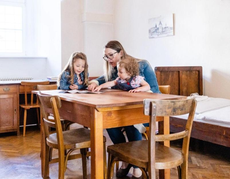 a woman and two children sitting at a wooden table at Zisterzienserstift Lilienfeld in Lilienfeld