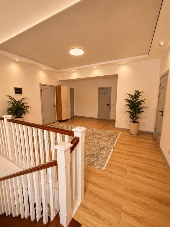an empty room with stairs and potted plants at Babushka House Hostel in Bishkek