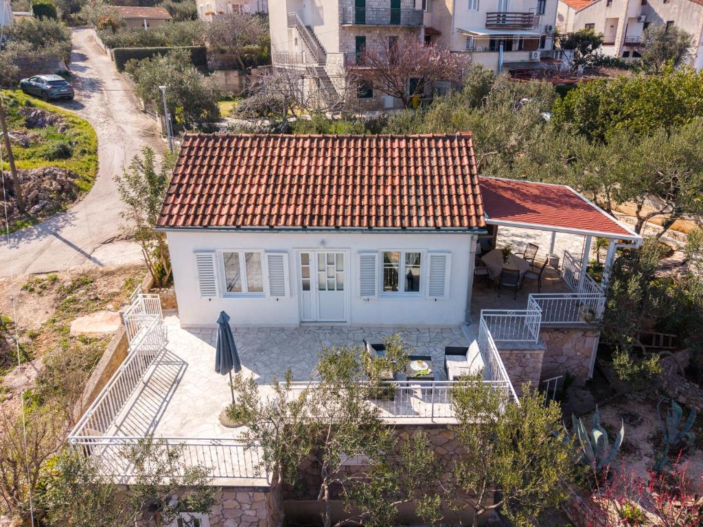 a small white house with a red roof at Kuća Lucija in Supetar