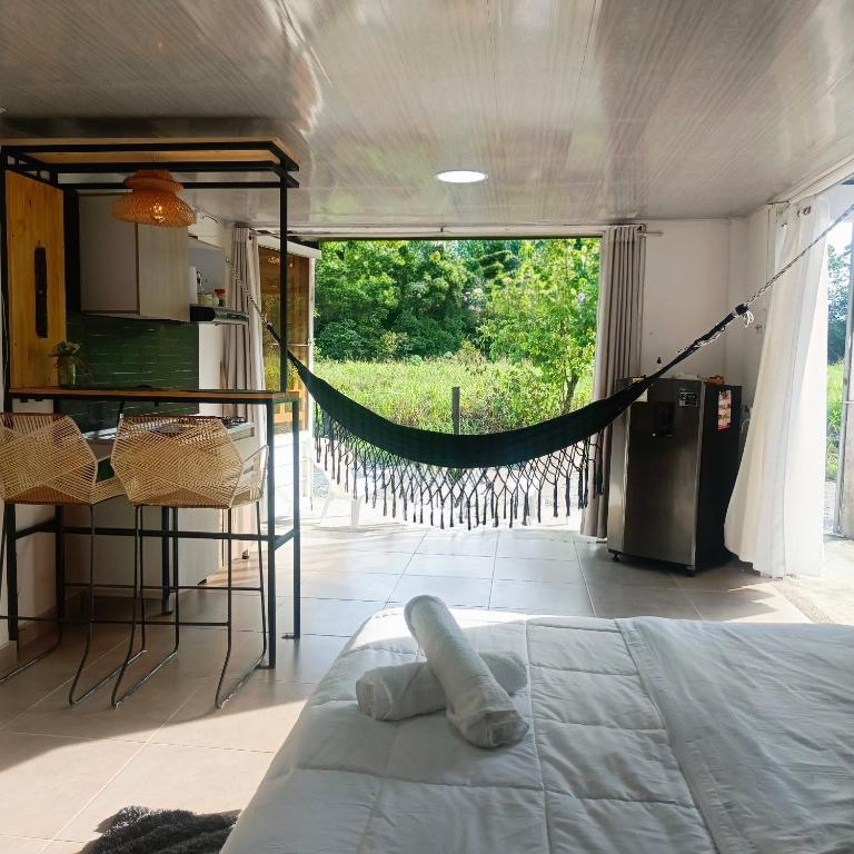 a room with a bed and a hammock in it at Suite campestre a 5 minutos del parque con aire acondicionado in Acacías