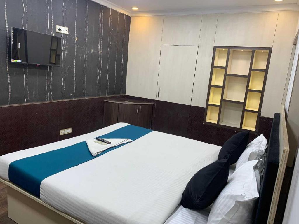 a bedroom with a bed with a tv on the wall at Hotel O The Diamond Palace in Kolkata