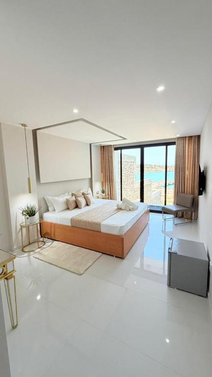 a bedroom with a large bed and a large window at Vista Mar Suites in Praia