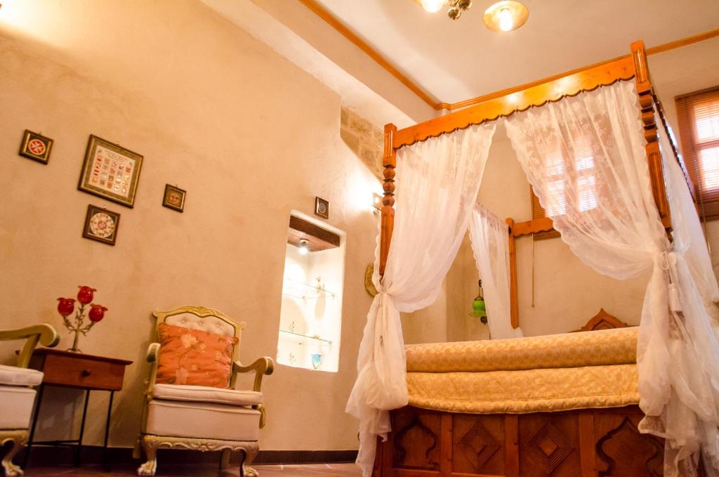 1 dormitorio con cama con dosel y silla en Elafusa Luxury Apartment, en Rodas
