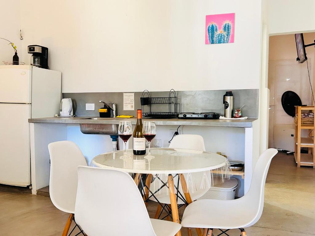 a kitchen with a table with wine bottles and chairs at Los Olivos Apart in Cafayate
