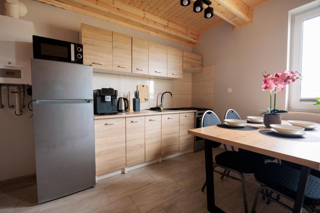 a kitchen with a table and a refrigerator at Agroturystyka Oliweczka 31 in Potok Wielki