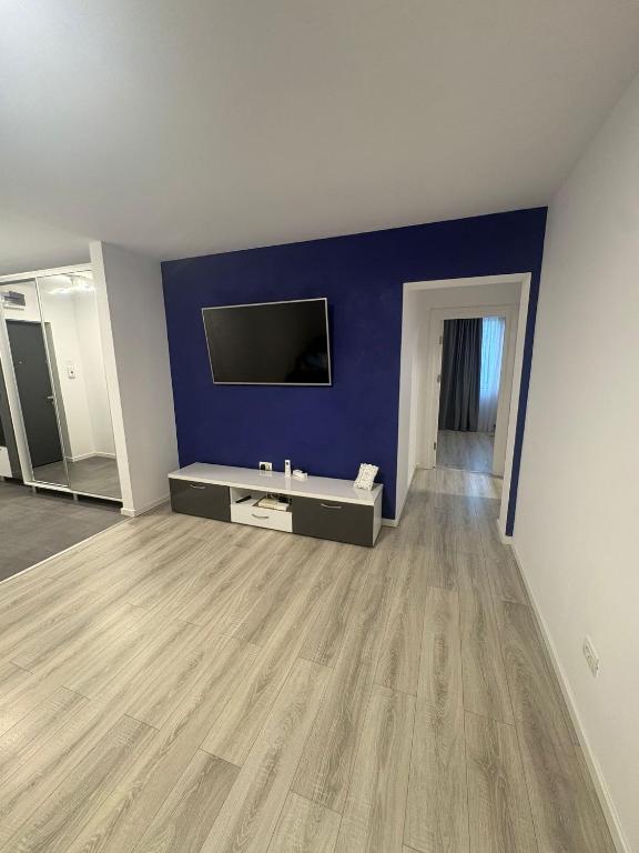 a living room with a blue wall and a tv at Iris central Mangalia 2 bedroom apartment in Mangalia