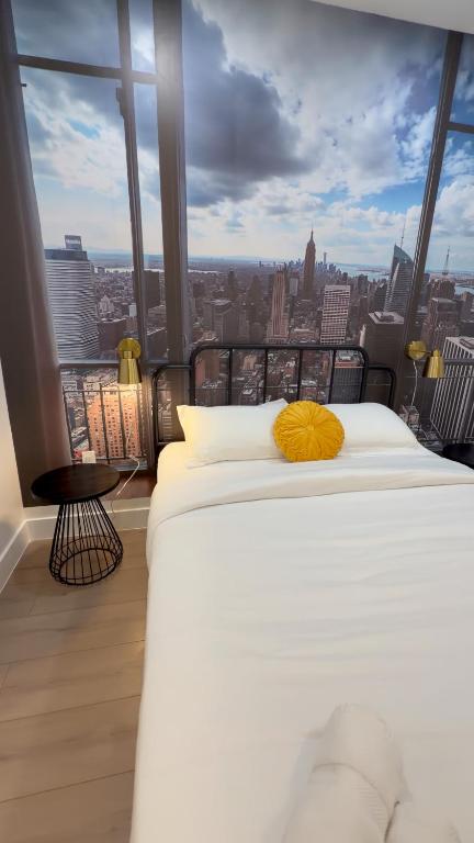 a bed in a room with a view of a city at Soho House - 20 Min to NYC - Breakfast Included- A in Jersey City
