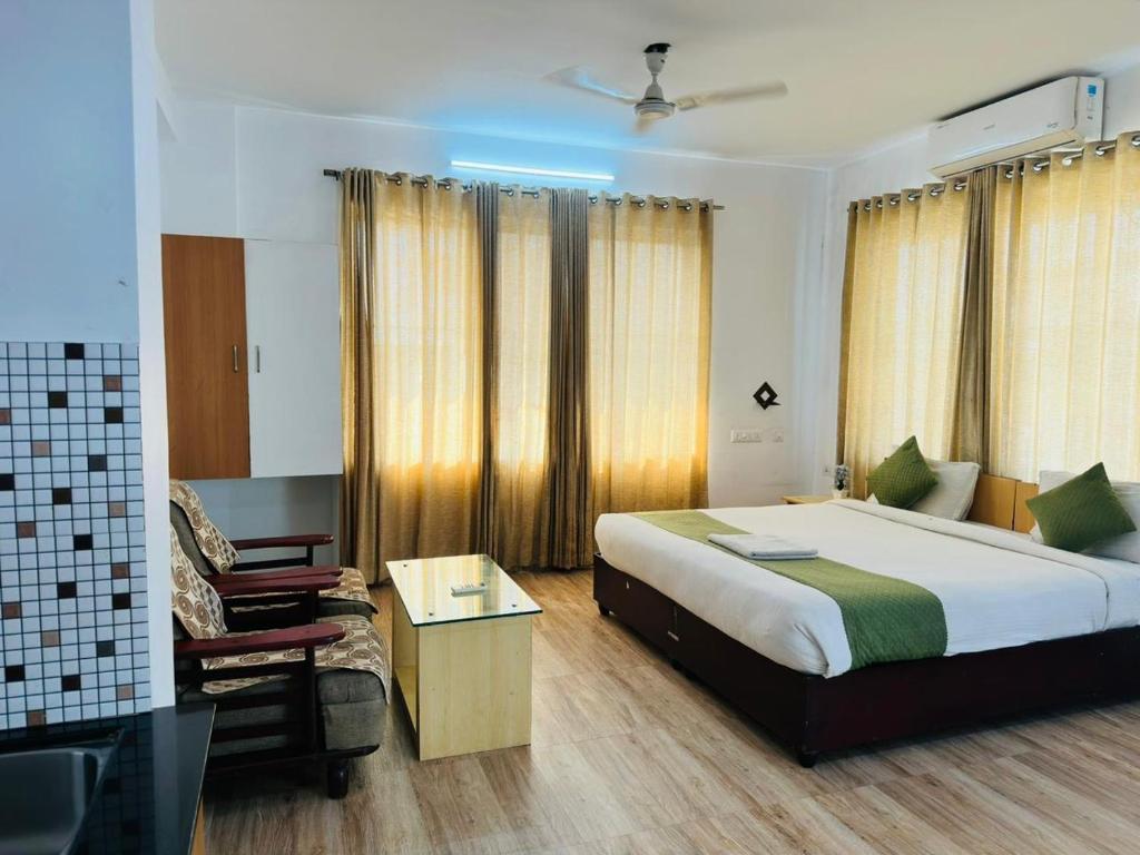 a bedroom with a large bed and a chair at Melvet Residency in Cochin