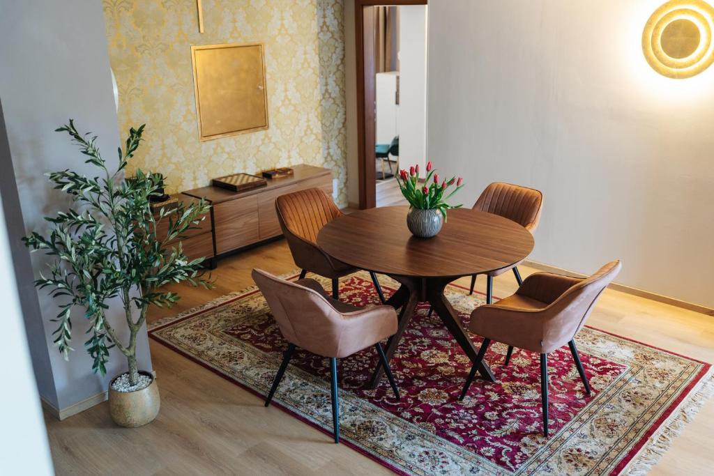 a dining room with a table and chairs on a rug at Boutique Apartments Daniela in Faak am See