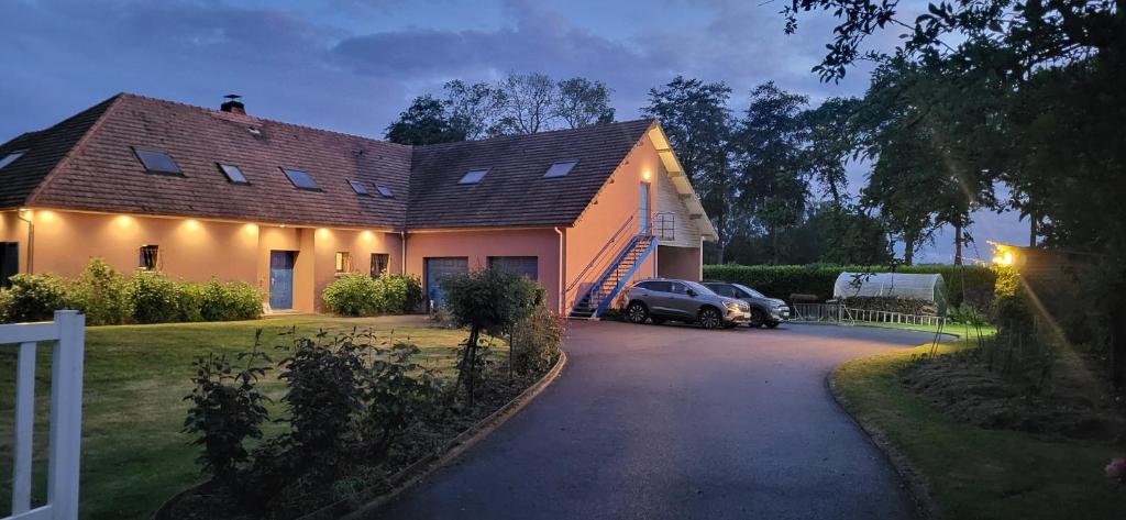 a house with a car parked in the driveway at proche d'Yvetot in Valliquerville