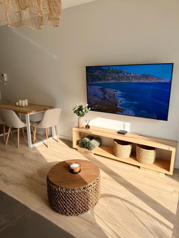 a living room with a large flat screen tv on a wall at Moon&Mori in Augustów