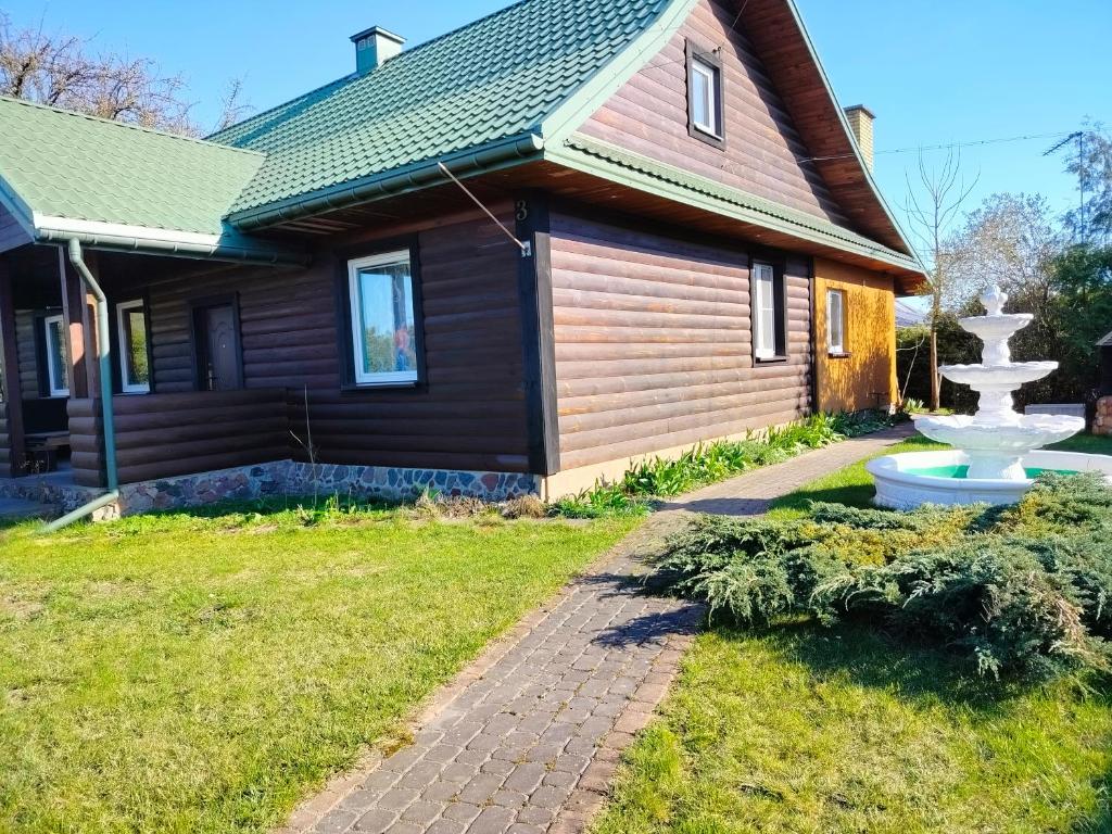 a house with a fountain in the yard at Siedlisko Grzegorza in Leśniki