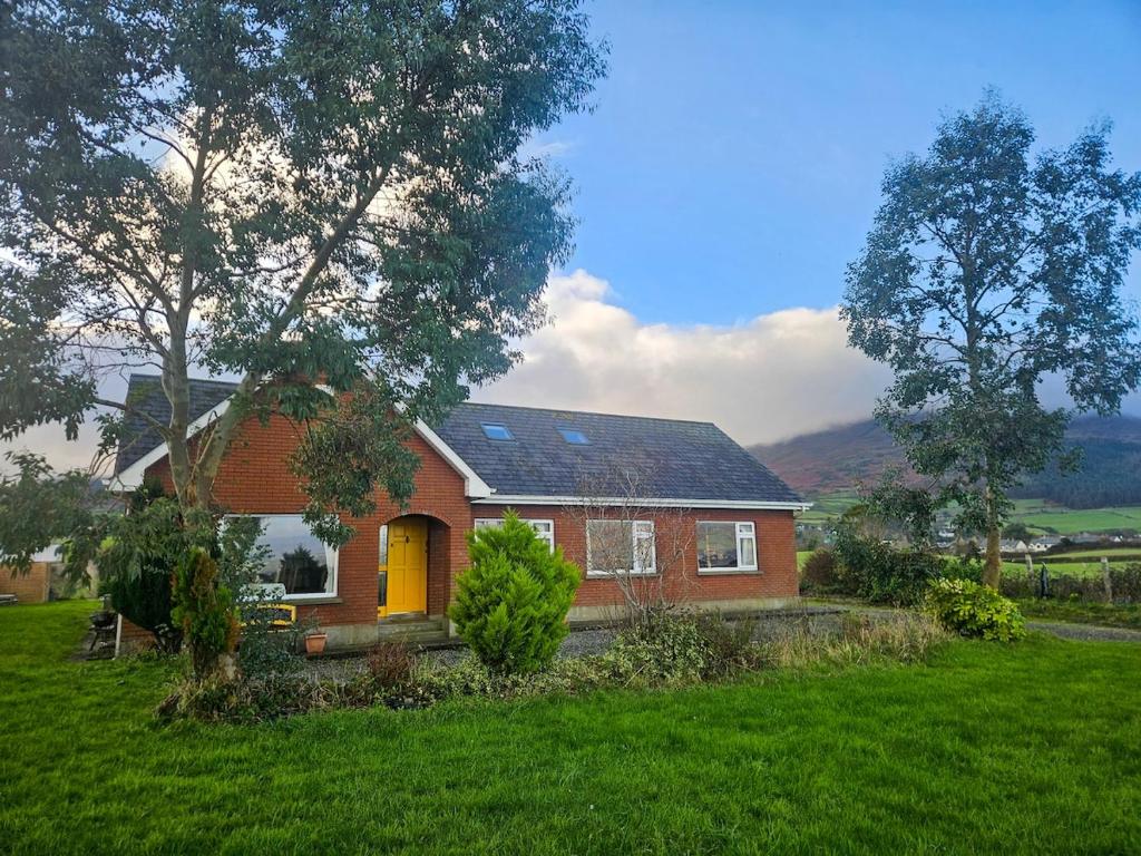 a red brick house with a yellow door in a yard at Bella Vista in Carlingford