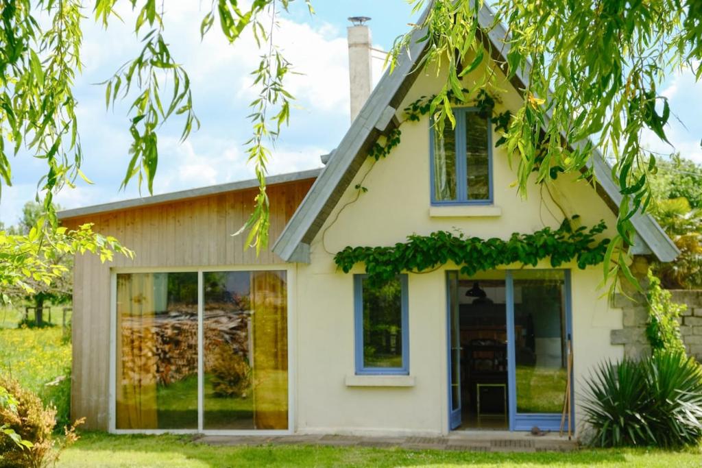a white house with windows and ivy at Le refuge, 4 personnes in Envermeu