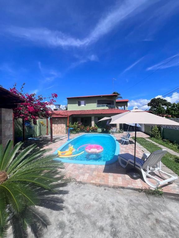 a house with a swimming pool in a yard at Pitimbu Beach House Rosi in Pitimbu