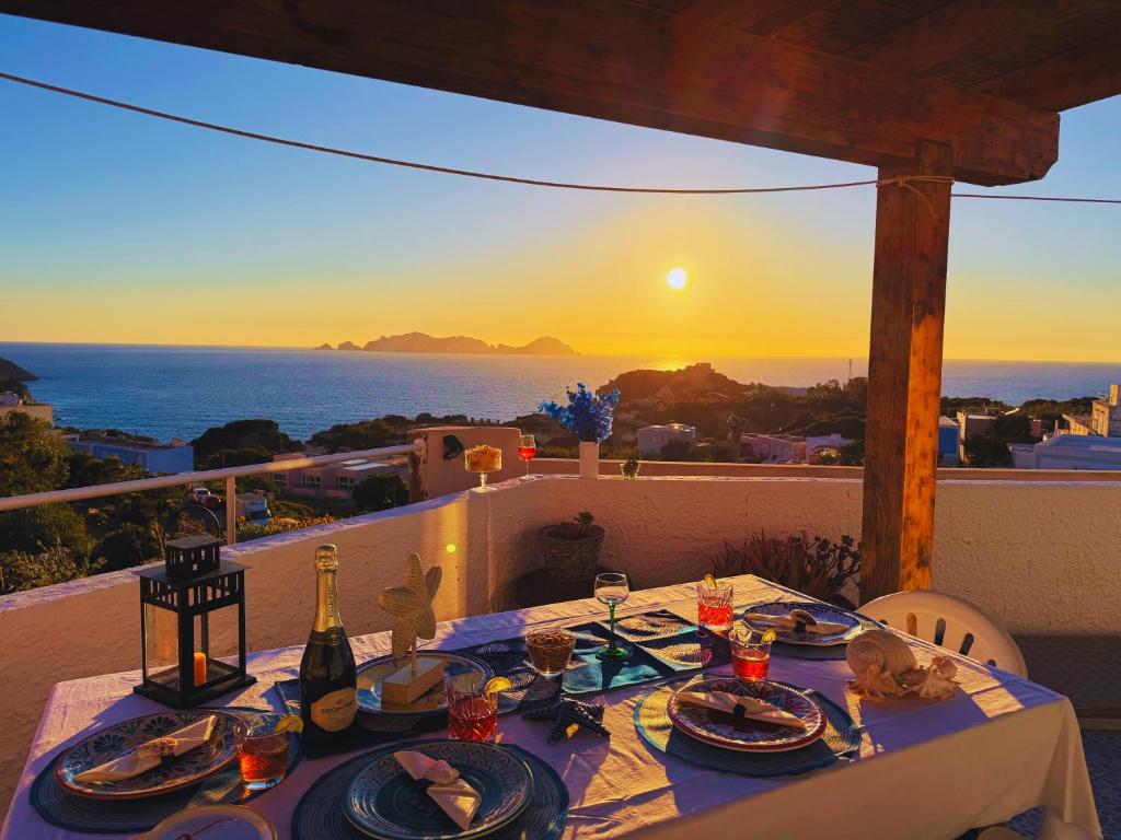 a table with plates of food and a bottle of wine at Ponzamania Terrazza sul tramonto in Ponza