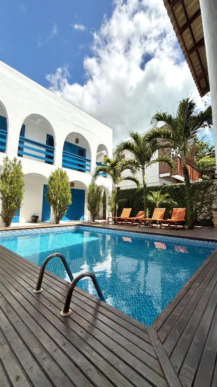 a pool at a resort with chairs and a building at Casa boa vida in Jericoacoara