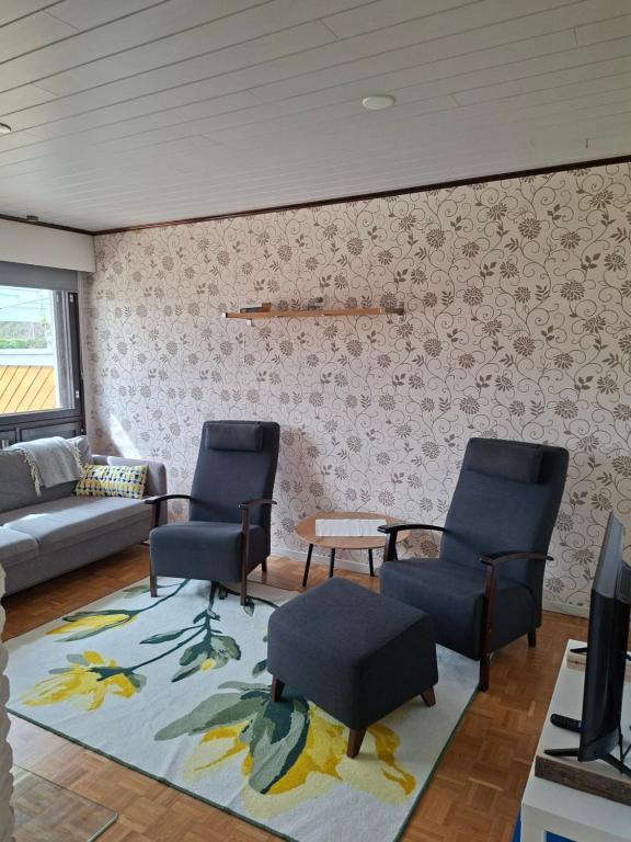 a living room with chairs and a couch and a table at Huoneisto Rivimerta, Siikajoki in Siikajoki