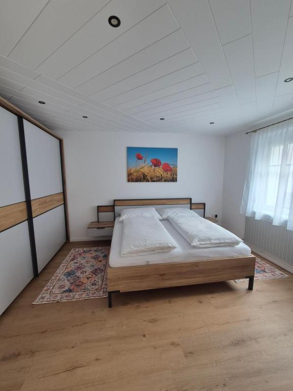 a bedroom with a bed in a white room at Panzers Ferienwohnungen in Asparn an der Zaya