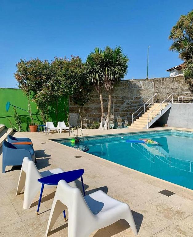 a swimming pool with white chairs and chairs next to it at Casa Augusta - QUINTA in Penafiel