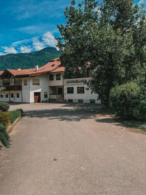 a large white building with a tree in front of it at Gisshübelhof Apartments in Lana