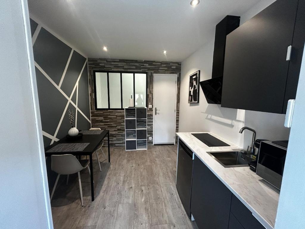 a kitchen with a table and a dining room at Le Petit Gaillard in Les Andelys