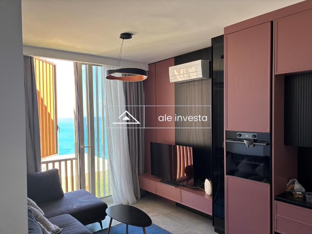 a living room with a couch and a tv at Green Coast 244d - by Ale Investa in Palasë
