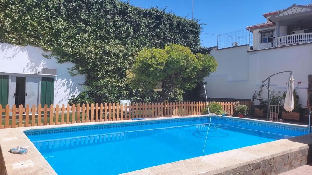 a blue swimming pool in front of a house at Casa El Jazmín in Alfacar