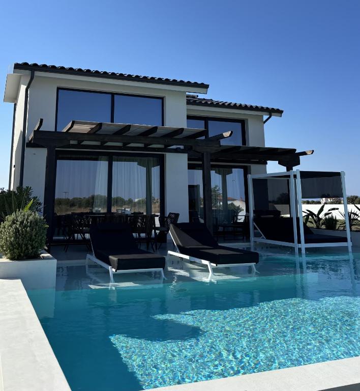 a villa with a swimming pool and a house at ZOSANA Villa in Kallithea Halkidikis