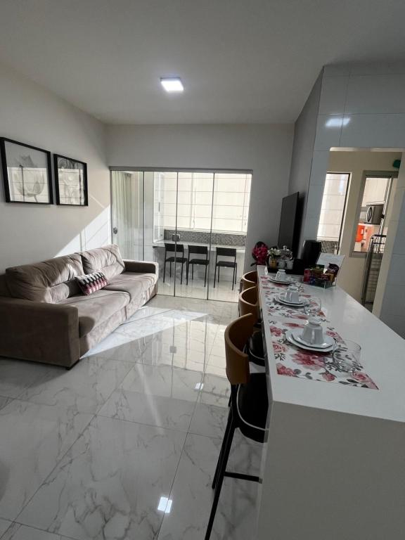 a kitchen and living room with a couch and a table at Apartamento Petúnia 2qto até 3 pessoas Res Unique in Goiânia