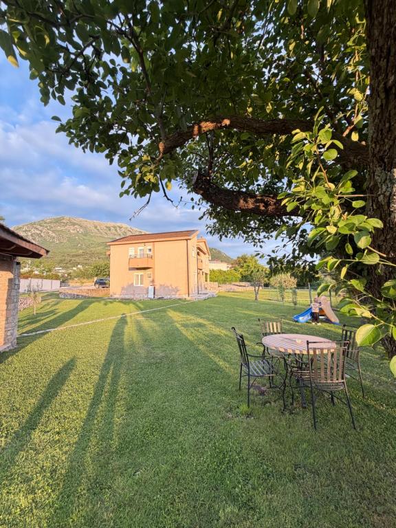 a table and chairs under a tree in a yard at Casa nel verde in Bar