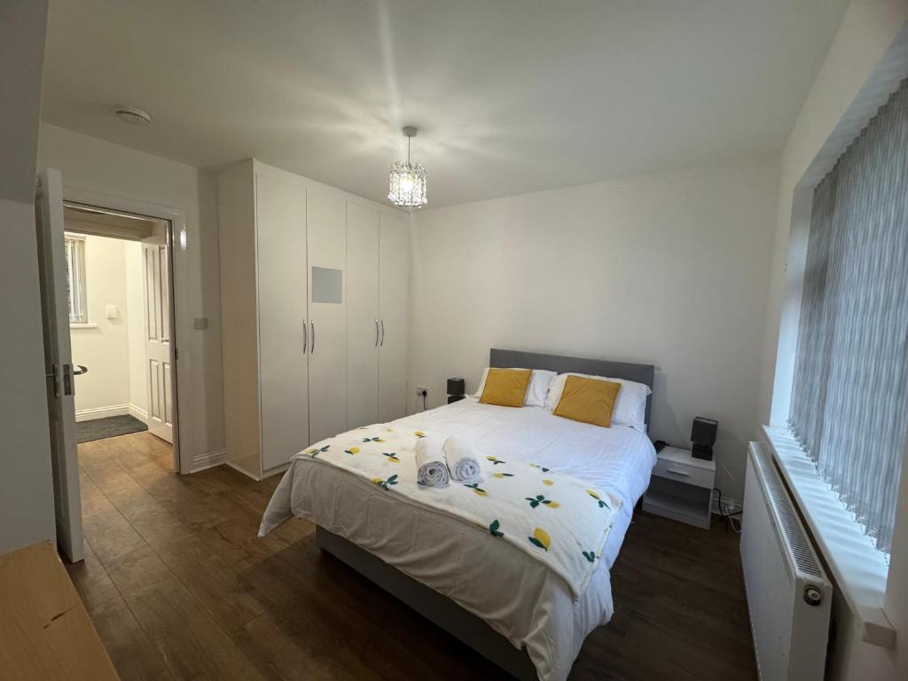 a bedroom with a large white bed with yellow pillows at London Heathrow Hayes Escape in South Ruislip Station