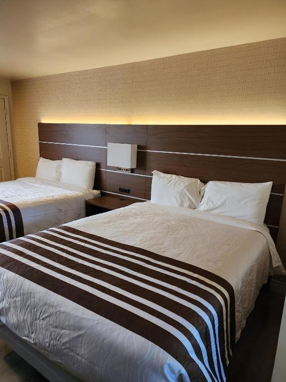 a hotel room with two beds and a headboard at Knights Inn Lindsay in Lindsay