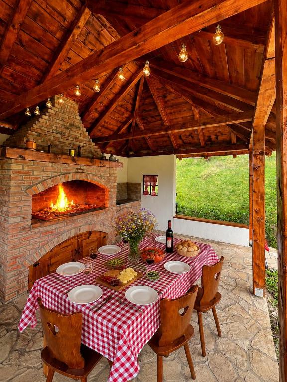 a table with a red and white checkered table cloth and a fireplace at Vikendica River Uvac in Rudo