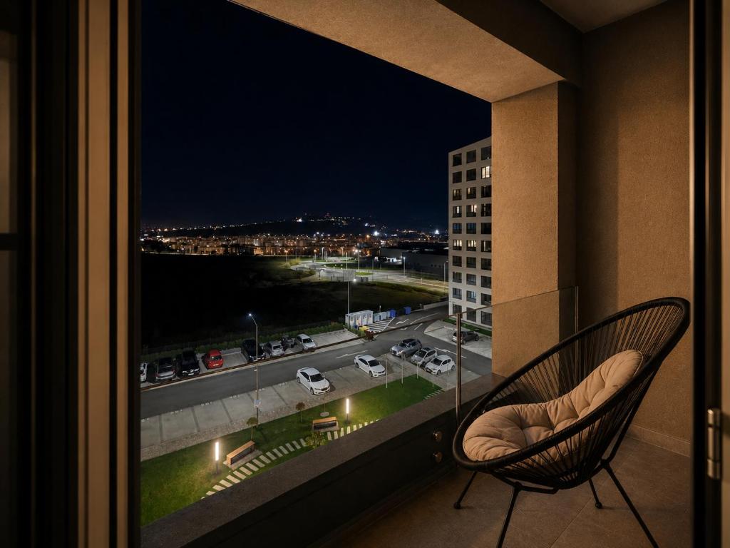 a balcony with a chair and a view of a city at The Loft, An Architects Dream in Târgu-Mureş