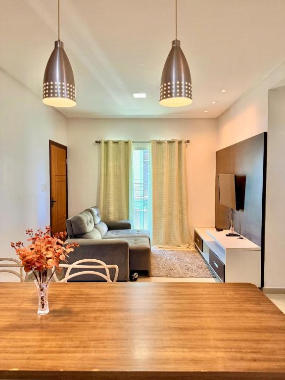a living room with a table and a couch at Apartamento de 2 Quartos no Centro in Imperatriz